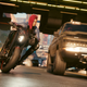 V rides a motorcycle on a busy street in Cyberpunk 2077.